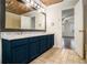 Bathroom with dual sink vanity, large mirror, wood ceiling, and decorative tile floor at 930 Camden Hill Ct, Lawrenceville, GA 30046
