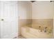 Bathroom with tiled tub, neutral walls, and chrome fixtures at 930 Camden Hill Ct, Lawrenceville, GA 30046