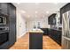Well-lit kitchen features dark cabinetry, stainless appliances, wood floors, and central island with cooktop at 930 Camden Hill Ct, Lawrenceville, GA 30046