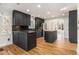 Modern kitchen with sleek black cabinets, stainless steel appliances, and a center island at 930 Camden Hill Ct, Lawrenceville, GA 30046