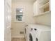 Convenient laundry room with white washer and dryer, cabinet storage, and window at 930 Camden Hill Ct, Lawrenceville, GA 30046