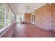 An enclosed sunroom features brick walls, screen windows, and terra cotta tiled floors at 11765 Mountain Laurel Dr, Roswell, GA 30075