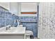 Bathroom featuring blue textured tile, a shower with patterned curtain, and a white sink at 1949 Capri Dr, Decatur, GA 30032