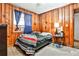 Cozy bedroom featuring wood-paneled walls, bright window, and warm lighting at 1949 Capri Dr, Decatur, GA 30032