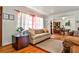 Comfortable living room featuring sofas, hardwood floors, and large window views into the dining room at 1949 Capri Dr, Decatur, GA 30032