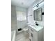 Bathroom featuring white vanity, a sleek mirror, tile floors, and a bathtub with a shower at 2403 Dawn Dr, Decatur, GA 30032