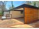 Attached carport showing modern wood accents, painted brick, and the covered side entrance to the charming home at 2403 Dawn Dr, Decatur, GA 30032
