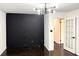 Dining room featuring dark wood floors, a modern chandelier, and a decorative black accent wall at 2403 Dawn Dr, Decatur, GA 30032