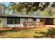 Inviting single-story home featuring painted brick, a modern wood-accented carport, and a charming front porch at 2403 Dawn Dr, Decatur, GA 30032