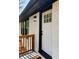 Close up of the home's entry featuring a painted brick exterior, modern lighting, and a bright white door at 2403 Dawn Dr, Decatur, GA 30032