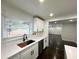 Bright kitchen with stainless steel sink, white cabinets, and quartz countertops with a view to the living room at 2403 Dawn Dr, Decatur, GA 30032