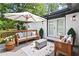 Outdoor patio is decorated with comfortable seating, potted plants, and a decorative umbrella at 2403 Dawn Dr, Decatur, GA 30032
