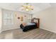 Cozy bedroom featuring a tray ceiling, ceiling fan, and modern wood-look flooring at 370 Burton Dr, Douglasville, GA 30134