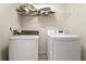 Functional laundry area with white washer and dryer and overhead shelving at 370 Burton Dr, Douglasville, GA 30134