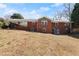 A sprawling backyard showing a brick home and covered patio, surrounded by mature trees at 1421 Downs Sw Dr, Atlanta, GA 30311