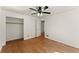 Bedroom boasts hardwood floors, a ceiling fan, and an open closet at 1421 Downs Sw Dr, Atlanta, GA 30311