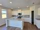 Modern kitchen with white cabinets, granite countertops, stainless steel appliances, and island with sink at 2724 Mourning Dove Drive Lot 32, Grayson, GA 30017