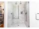 Modern shower with marble tiling, a bench, rainfall shower heads, and a glass enclosure at 4541 Wieuca Ne Rd, Atlanta, GA 30342