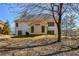 Exterior backyard view of a white home on a hill, surrounded by trees at 305 Collegiate Dr, Powder Springs, GA 30127