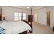 Well-lit primary bedroom featuring a four-poster bed and views into the en suite bathroom at 305 Collegiate Dr, Powder Springs, GA 30127