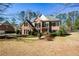 Beautiful brick home boasts mature trees, lush landscaping, and a well-maintained lawn at 305 Collegiate Dr, Powder Springs, GA 30127
