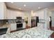 Bright kitchen with granite countertops, tile backsplash, white cabinetry and stainless steel appliances at 305 Collegiate Dr, Powder Springs, GA 30127