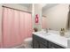 Modern bathroom featuring a shower with a pink curtain, vanity, and mirror at 4336 Walsh Dr, Dunwoody, GA 30338