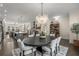 Open floor plan of dining room with decorative chandelier, leading into a spacious modern kitchen at 4336 Walsh Dr, Dunwoody, GA 30338