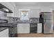 Modern kitchen features white cabinets, black appliances, and a decorative backsplash, creating a stylish cooking space at 4382 Conwhey Sw Ct, Smyrna, GA 30082