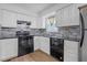 Modern kitchen features white cabinets, black appliances, and a decorative backsplash, creating a stylish cooking space at 4382 Conwhey Sw Ct, Smyrna, GA 30082