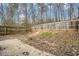 Large fenced-in backyard with trees and a small patio at 6962 Oakhill Cir, Austell, GA 30168