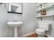 Cozy powder room with pedestal sink, tiled flooring, open shelving, and a comfort height toilet at 6962 Oakhill Cir, Austell, GA 30168