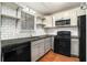 Well-organized kitchen featuring white subway tile, black appliances, and open shelving at 6962 Oakhill Cir, Austell, GA 30168