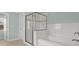 Bathroom showcasing a walk-in glass shower, bathtub with white tile surround, and natural light from a window at 2845 Echols Rd, Cumming, GA 30041