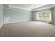 Bright bedroom featuring a large window, light-colored walls, and a neutral carpet at 2845 Echols Rd, Cumming, GA 30041