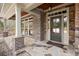 Charming front porch with stone flooring, brick pillars, and a stylish front door at 2845 Echols Rd, Cumming, GA 30041