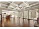 Spacious living room with hardwood floors, coffered ceiling, and access to a bright kitchen and outdoor deck at 2845 Echols Rd, Cumming, GA 30041