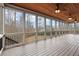 Large screened porch with wood ceiling and floors, featuring fans and views of a backyard and wooded area at 2845 Echols Rd, Cumming, GA 30041