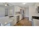 Kitchen with white cabinetry, stainless steel appliances, quartz countertops and hardwood floors at 3175 Justice Mill Nw Ct, Kennesaw, GA 30144