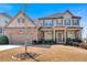 Charming two-story home featuring a brick and tan exterior with a well-manicured lawn at 257 Lakestone Pkwy, Woodstock, GA 30188