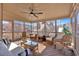 Bright screened-in porch with ceiling fan, outdoor seating, and wood flooring at 257 Lakestone Pkwy, Woodstock, GA 30188