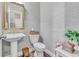 A powder room featuring updated wall paper, framed mirror, and pedestal sink at 257 Lakestone Pkwy, Woodstock, GA 30188