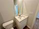 Well-lit bathroom with a vanity, toilet, and light wood-look flooring at 2624 Mourning Dove Drive (Lot 42), Grayson, GA 30017