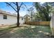 View of the backyard with its wooden fence and grassy area surrounded by trees at 368 Triumph Se Cir, Atlanta, GA 30354
