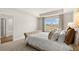 A primary bedroom boasts a decorative headboard, plush carpet, and a large window at 452 Reflection Dr # 19, Stockbridge, GA 30281