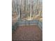 Backyard with a wood fence, fully covered in fallen leaves and surrounded by a forest landscape at 7123 Williamsburg Dr, Riverdale, GA 30274