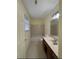 A bathroom with a tiled shower-tub combo, vanity, and window at 7123 Williamsburg Dr, Riverdale, GA 30274