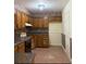 A cozy kitchen with brown wooden cabinets and a tile floor at 7123 Williamsburg Dr, Riverdale, GA 30274