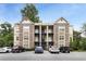 Apartment building with brick and beige facade, multiple balconies, and parking lot surrounded by mature trees at 1903 Anjaco Rd # 5, Atlanta, GA 30309