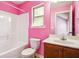 A lively pink bathroom includes a tub-shower combo and a vanity with good counter space, creating a cheerful atmosphere at 416 Culloden Moor Dr, Mcdonough, GA 30253